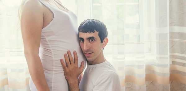 Portrait of man touching stomach of pregnant woman