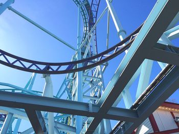 Low angle view of rollercoaster against clear blue sky