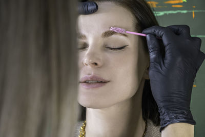 Close-up of woman applying make-up