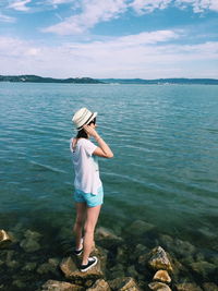 Full length of woman standing by river against sky