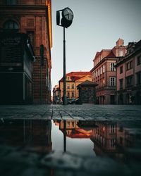 Buildings by canal against sky at dusk