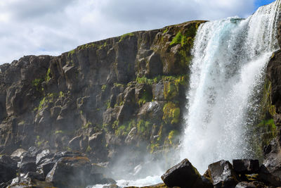 Scenic view of waterfall against sky