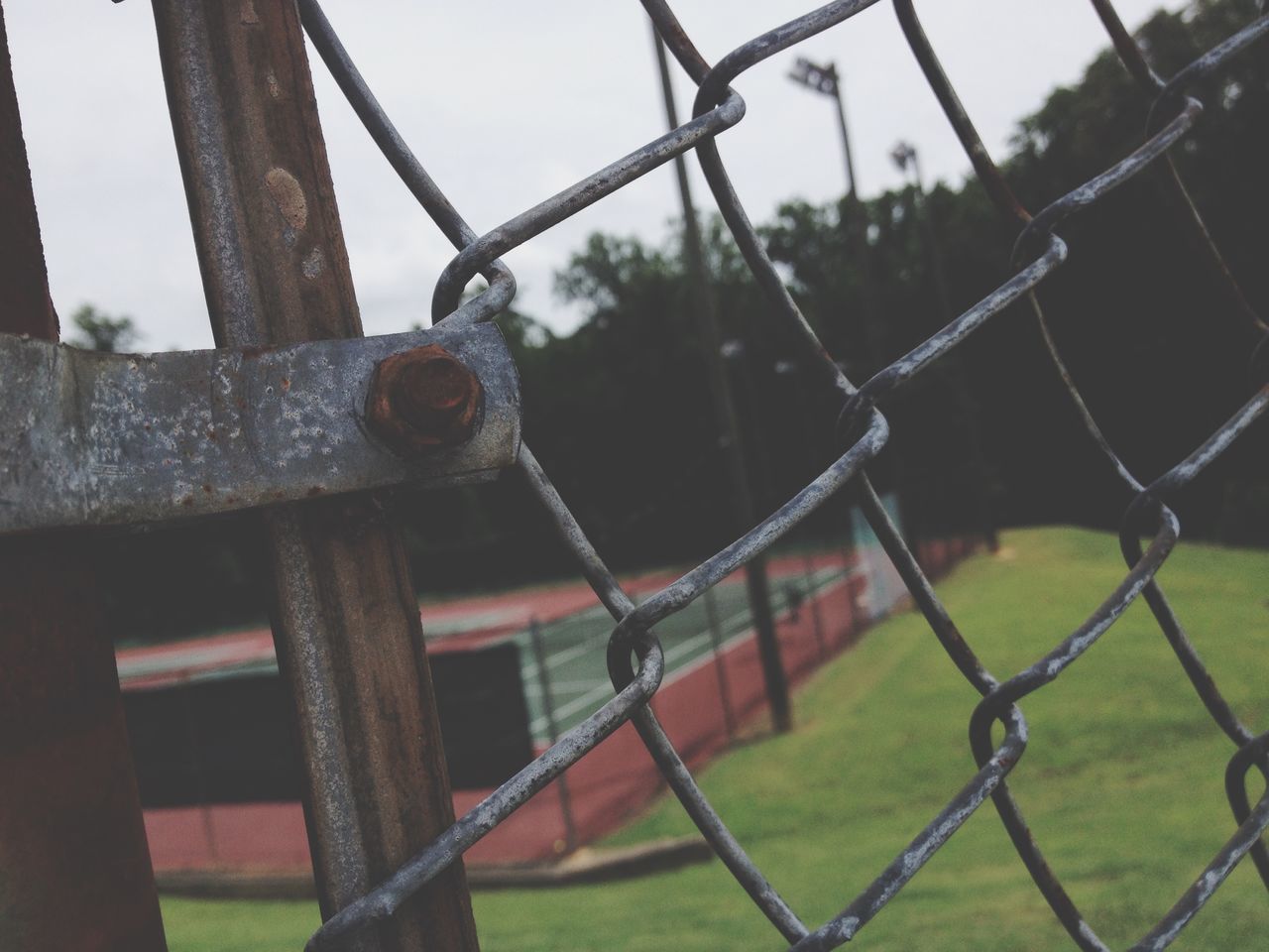 fence, metal, protection, chainlink fence, safety, security, focus on foreground, metallic, close-up, grass, day, barbed wire, field, railing, chain, outdoors, rusty, no people, padlock, sky