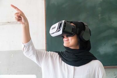 Woman wearing virtual reality simulator at home