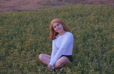 Portrait of a smiling young woman on field