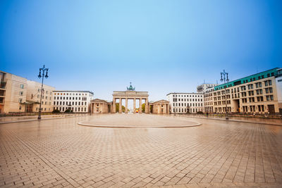 Buildings in town against clear blue sky