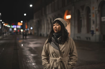 A young korean woman in a warm hat on a city street. 