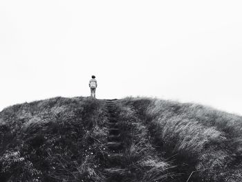 Rear view of person standing on hill