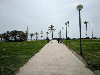 Street amidst grass against sky