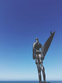 Low angle view of statue against clear blue sky