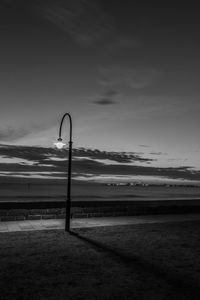 Illuminated street light by bay of water at night