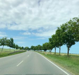 Road amidst trees against sky