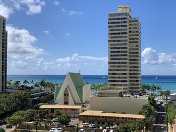 Buildings in city against cloudy sky