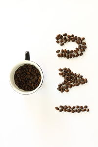 High angle view of coffee beans against white background