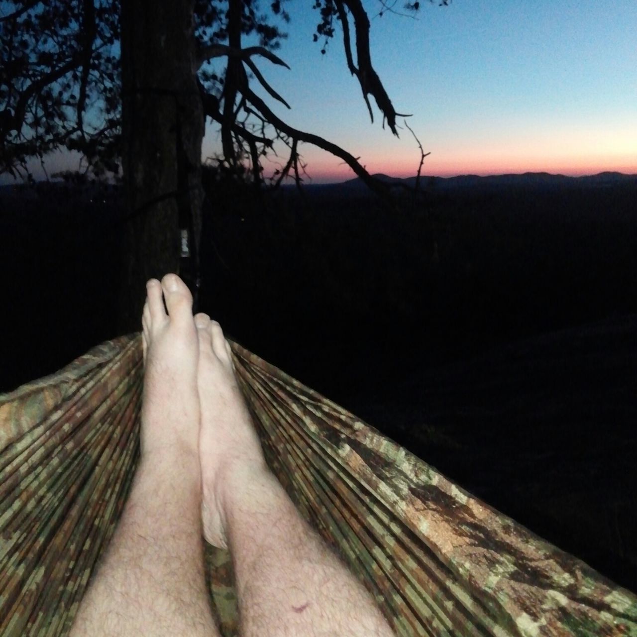 tree, low section, person, part of, lifestyles, leisure activity, personal perspective, clear sky, mountain, tranquility, sky, silhouette, unrecognizable person, nature, cropped, tranquil scene