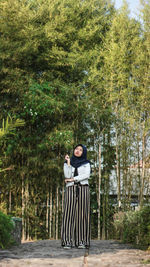 Man standing against trees and plants