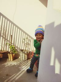 Cute boy standing against wall