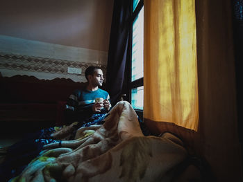 Man sitting on bed at home
