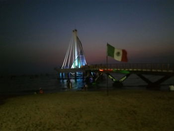 Lifeguard hut at beach against sky at night