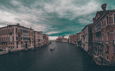 View of canal grande in venice against cloudy sky