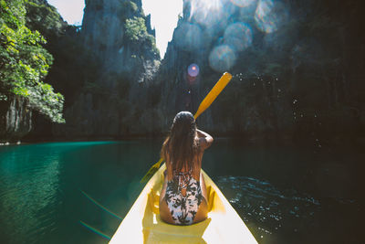 Rear view of woman kayaking in sea