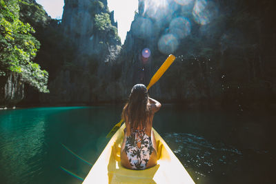 Rear view of woman with umbrella in water