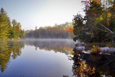 Reflection of trees in lake against sky during autumn