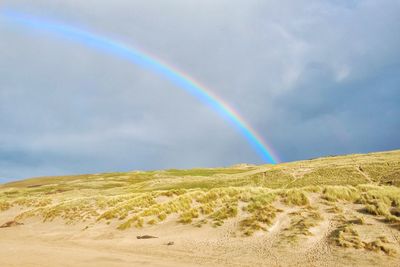 Rainbow over landscape against sky