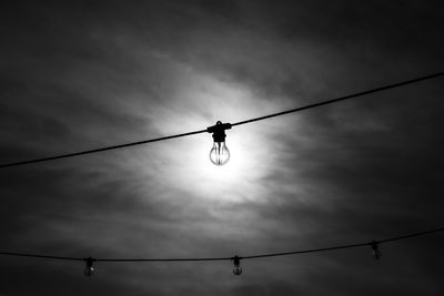 Low angle view of light bulbs against sky