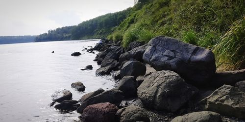 Rocks on sea shore against sky