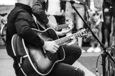 Midsection of men playing guitar