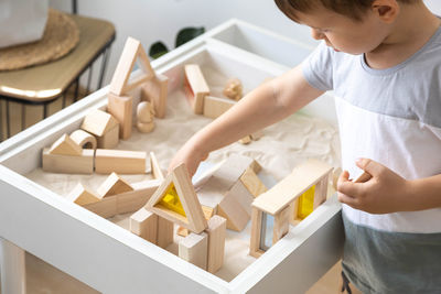 Side view of boy playing with toy blocks