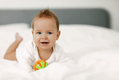 Portrait of cute baby lying down on bed
