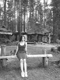 Full length of young woman sitting in forest