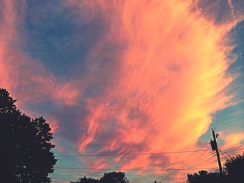 Silhouette of trees against cloudy sky