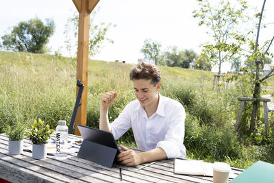 Portrait of young man using laptop while sitting on table