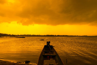 Silhouette boat in sea against sky during sunset