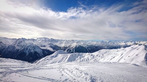 Snow covered mountains against cloudy sky