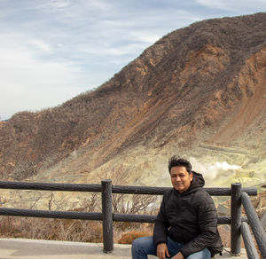 Portrait of man sitting against mountains