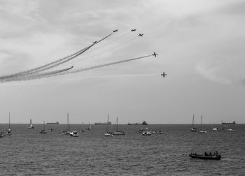 Sailboats in sea against sky