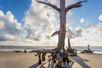 Metallic structure on beach against sky