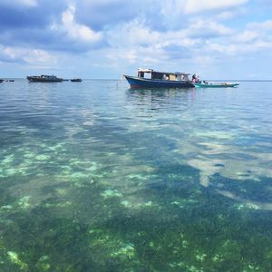 Boats moored on sea against sky