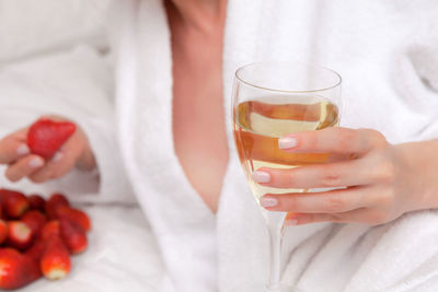 Midsection of woman drinking glass