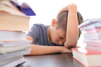 Rear view of girl sleeping on table