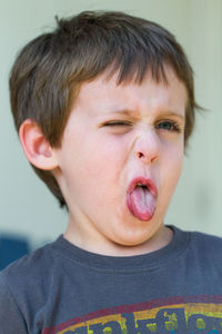 Little boy making disgusted face with tongue out