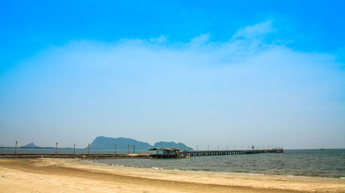 Scenic view of beach against blue sky