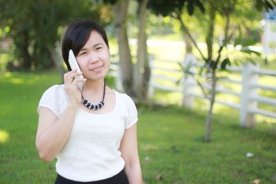 Beautiful young woman looking away while standing on land