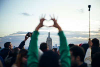 People watch from skyscrapers the buildings of new york at sunset and take photos with the mobile, united states