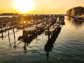 Boats in harbor at sunset