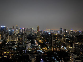 Illuminated cityscape against sky at night